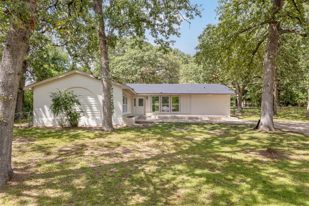 a view of a house with a patio and a yard