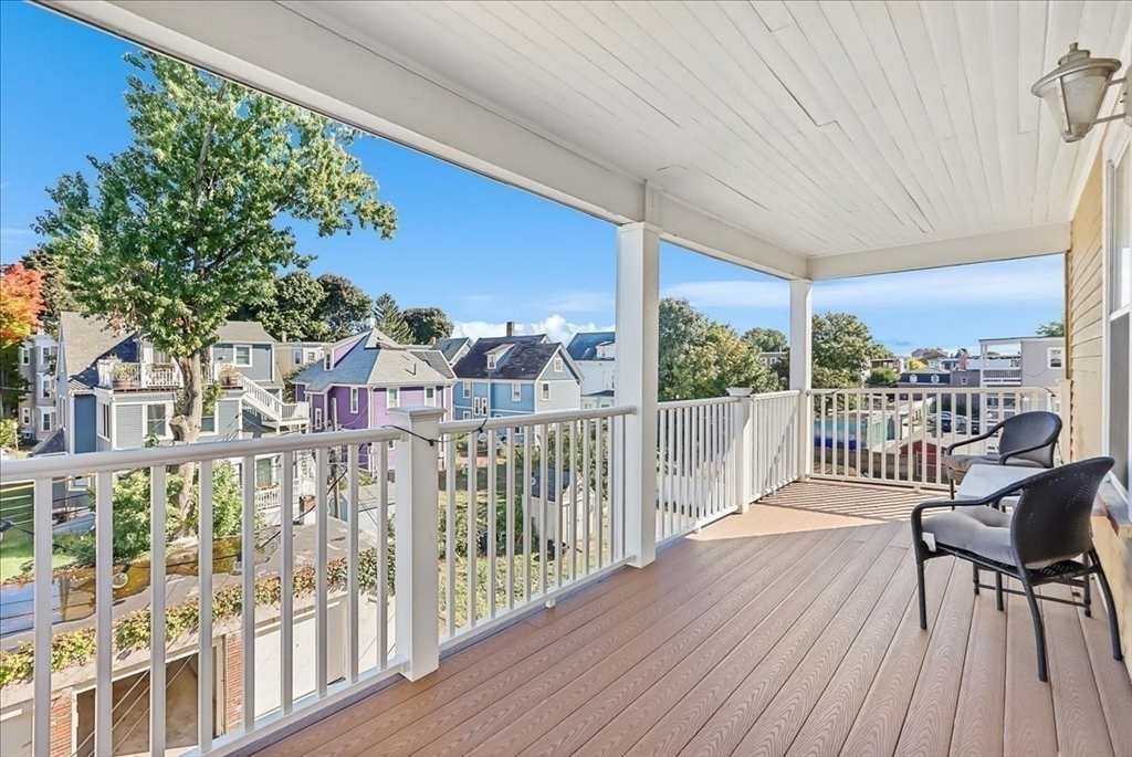 a view of a balcony with wooden floor and outdoor seating