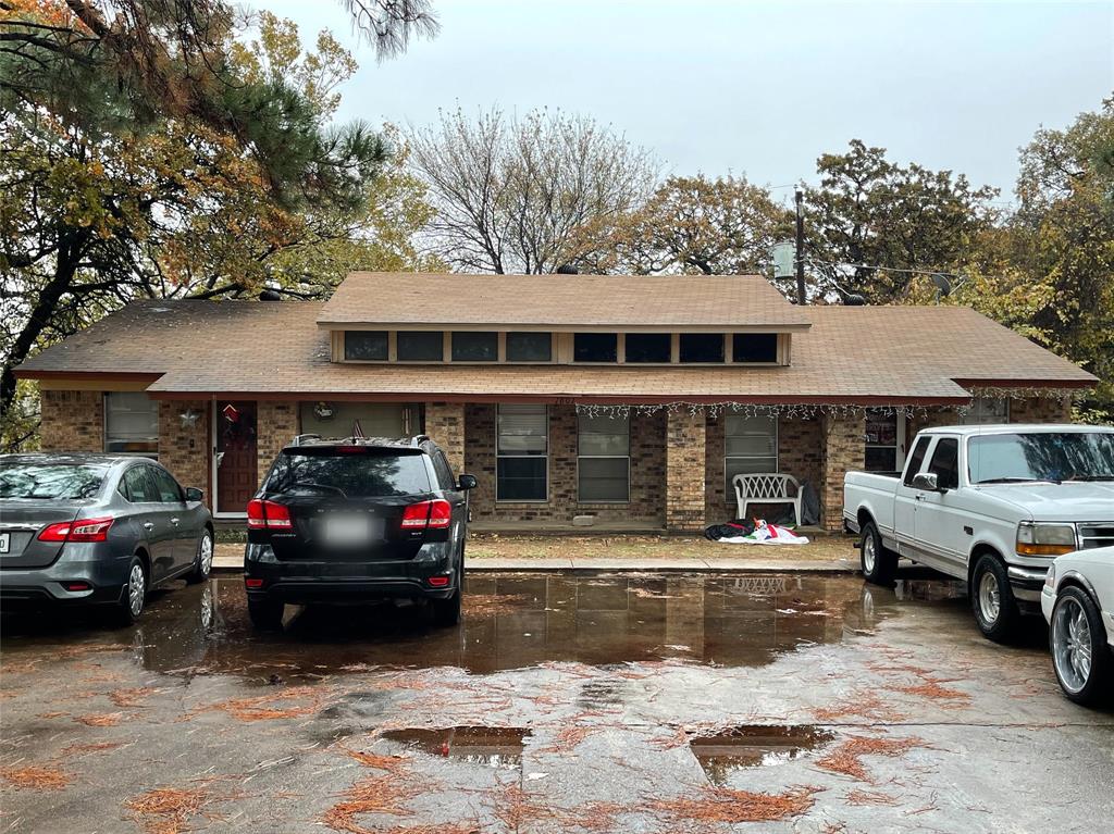 a front view of a house with cars parked