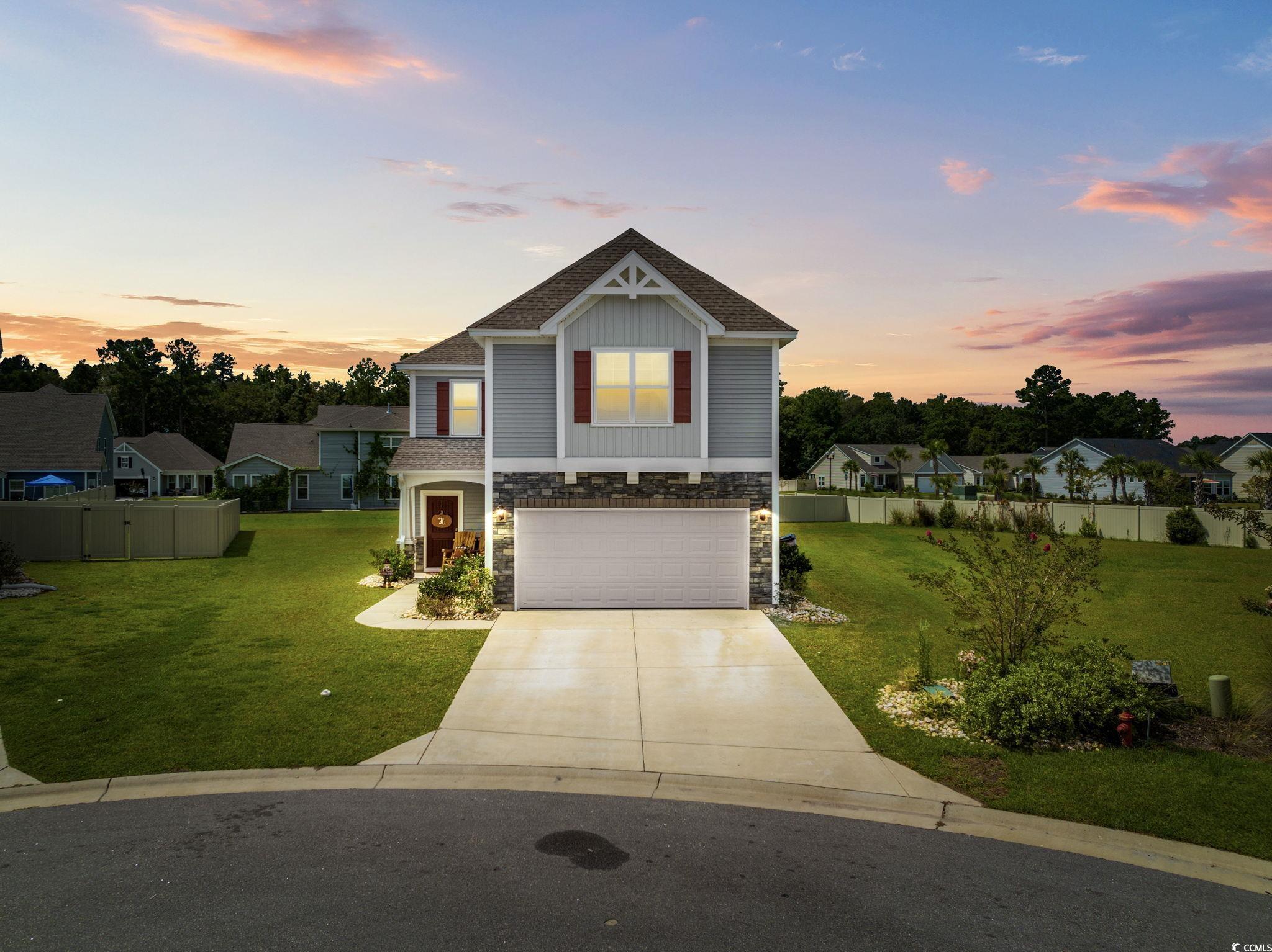 View of front facade with a garage and a yard