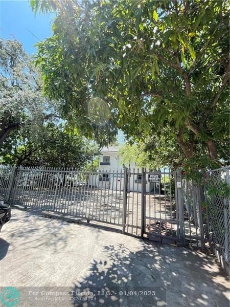 a view of a fence with trees in the background