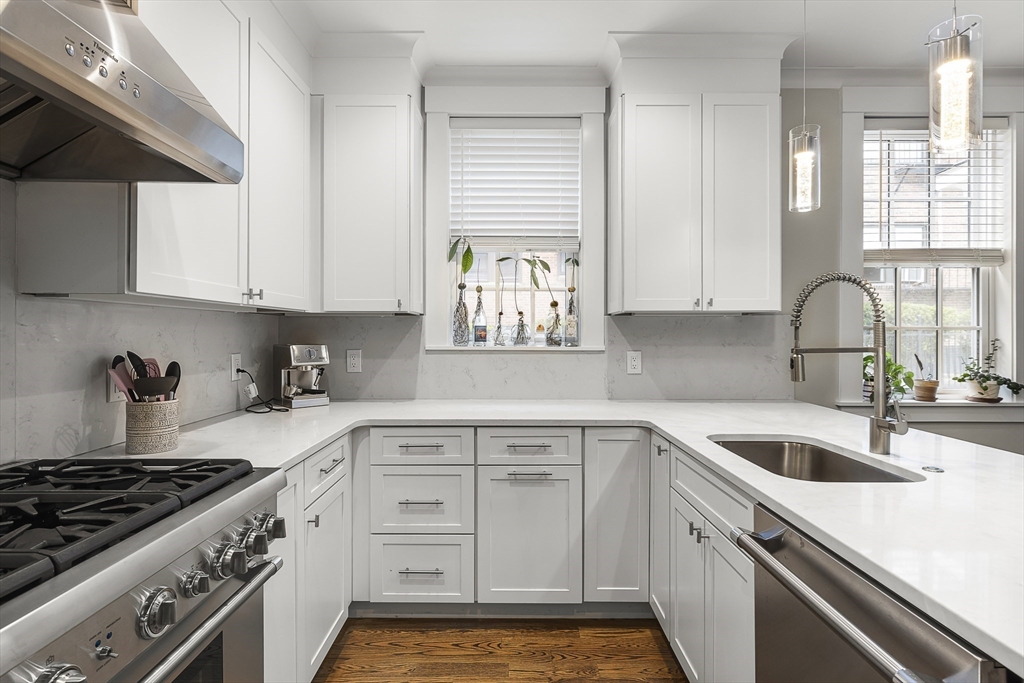 a kitchen with white cabinets and appliances