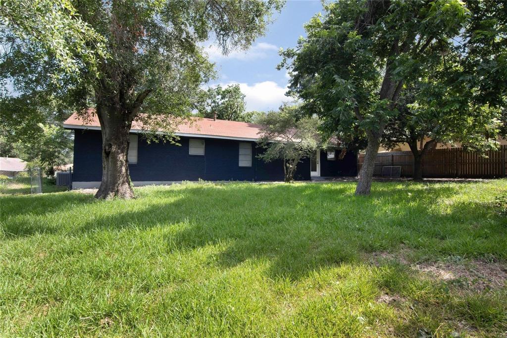 a front view of a house with garden and trees