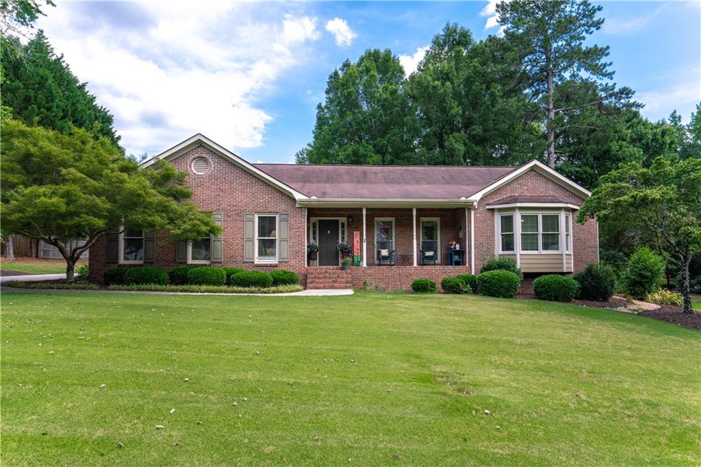 a front view of a house with a garden and trees