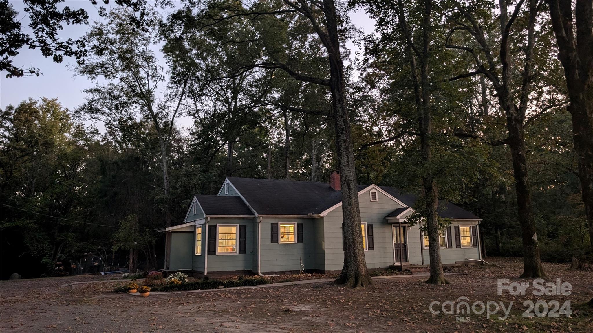 a front view of a house with a yard and tree s