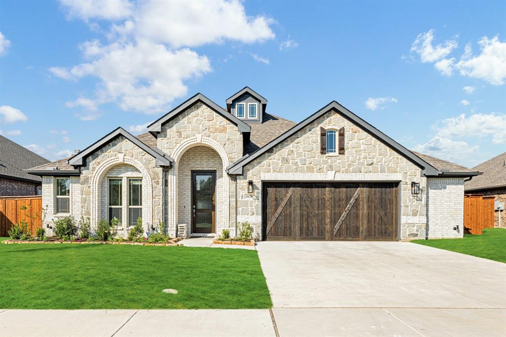 a front view of a house with a yard and garage