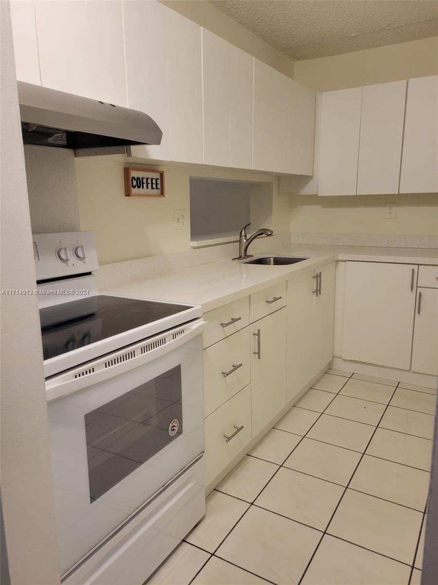 a kitchen with white cabinets and appliances