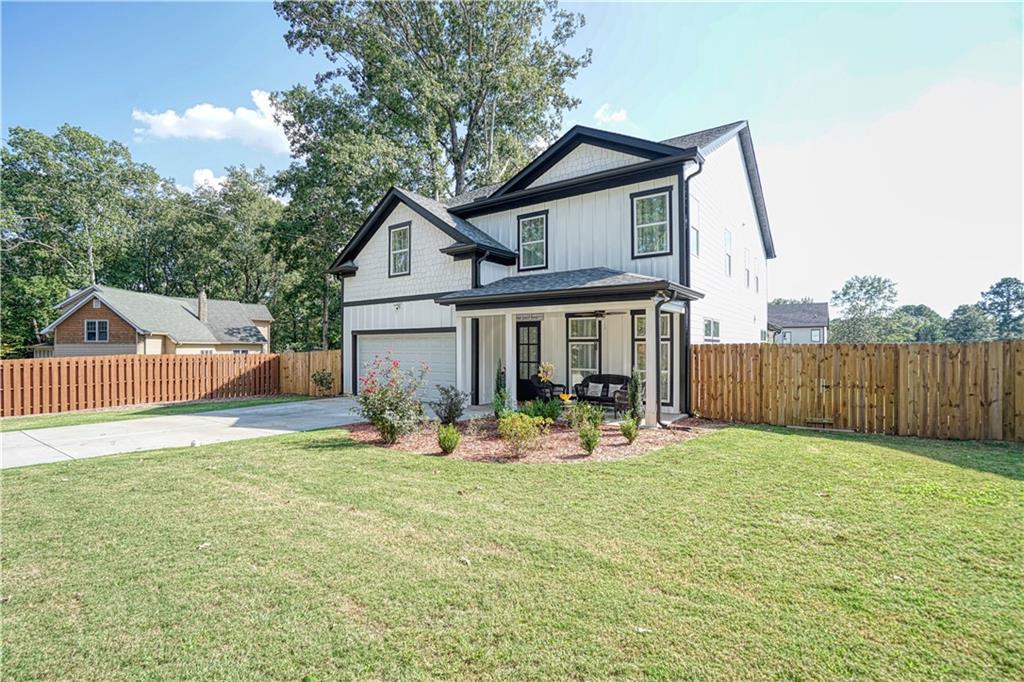 a front view of house with yard and trees in the background