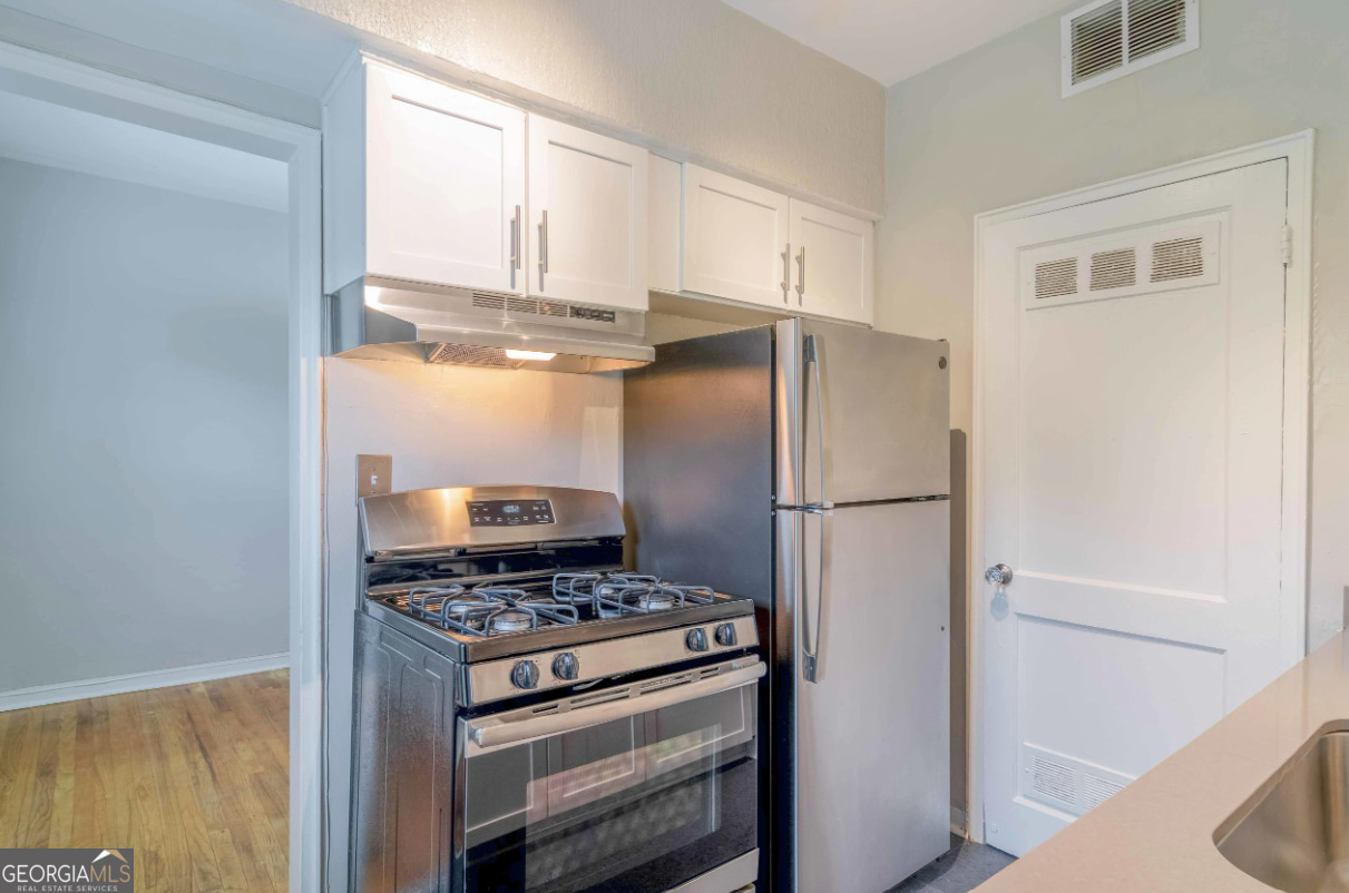 a kitchen with a refrigerator and a stove