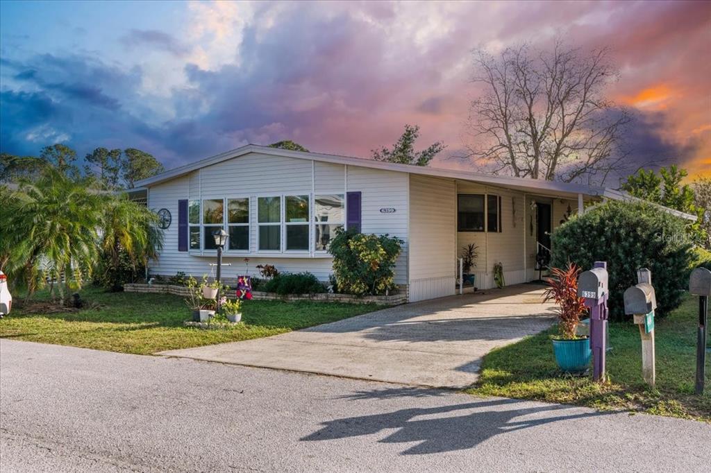 a front view of a house with a yard and potted plants