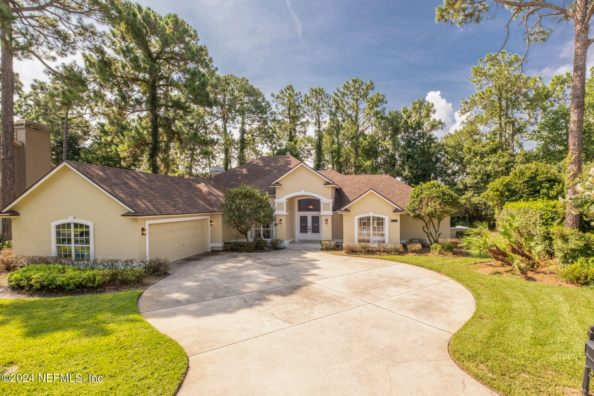 a front view of a house with a garden and trees