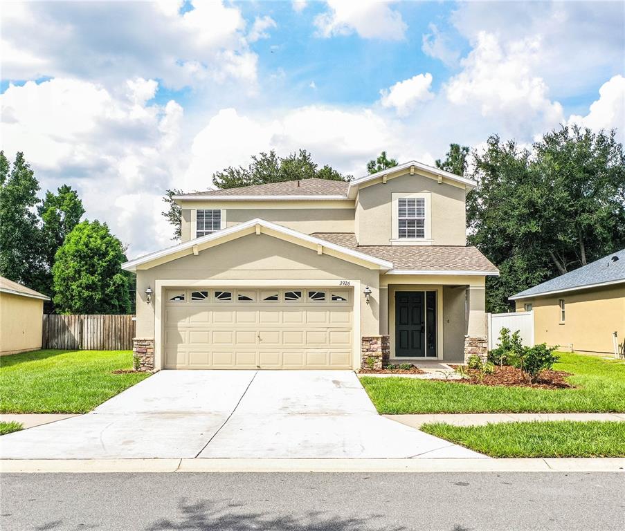 a front view of a house with a yard and garage