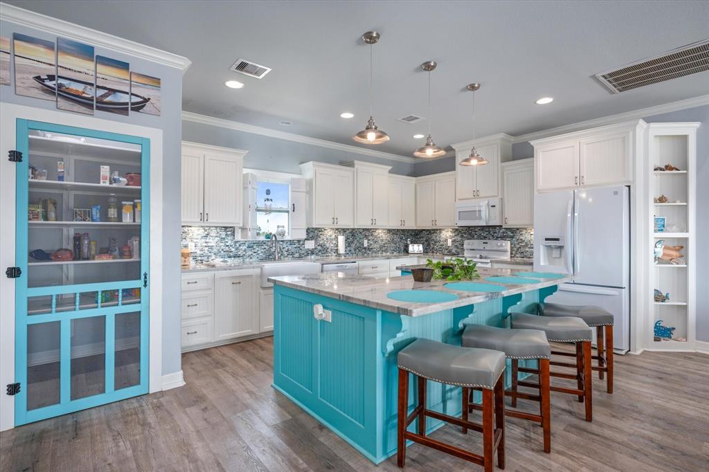 a kitchen with a table chairs refrigerator and cabinets