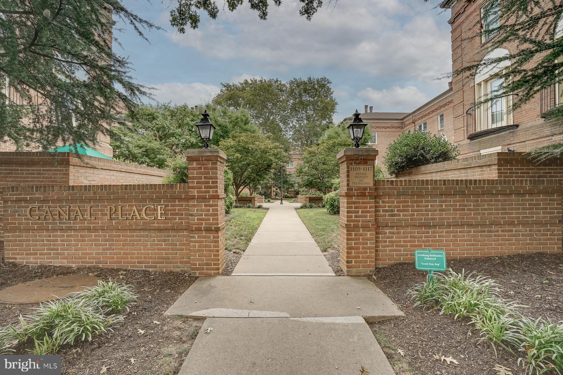 a view of a pathway with a brick wall