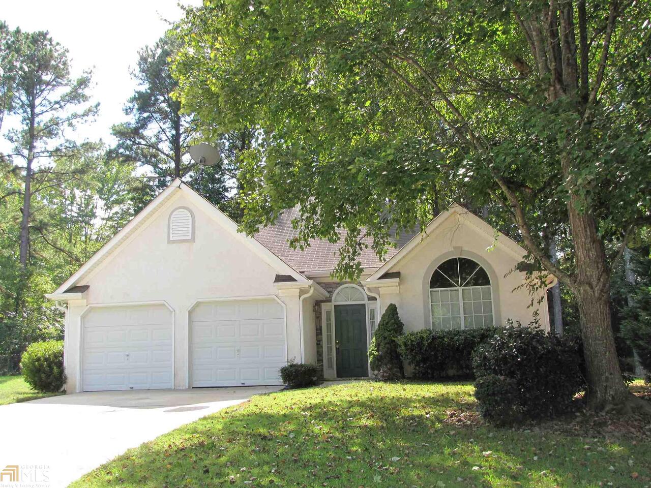 a front view of a house with yard and green space