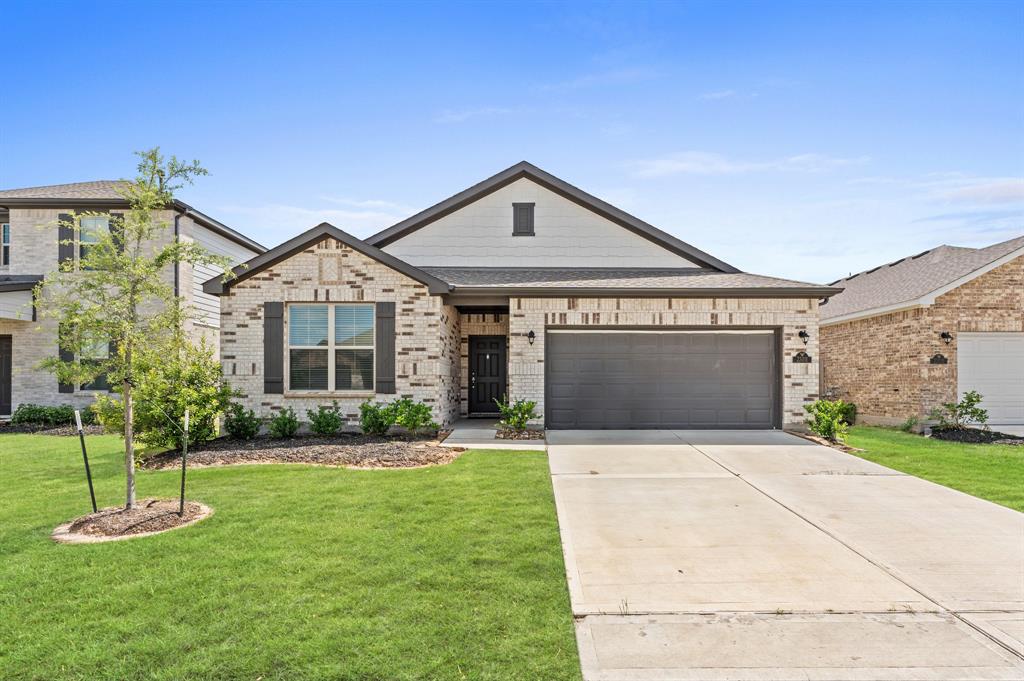 a front view of a house with a yard and garage