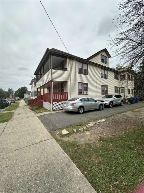 a front view of a building with cars parked