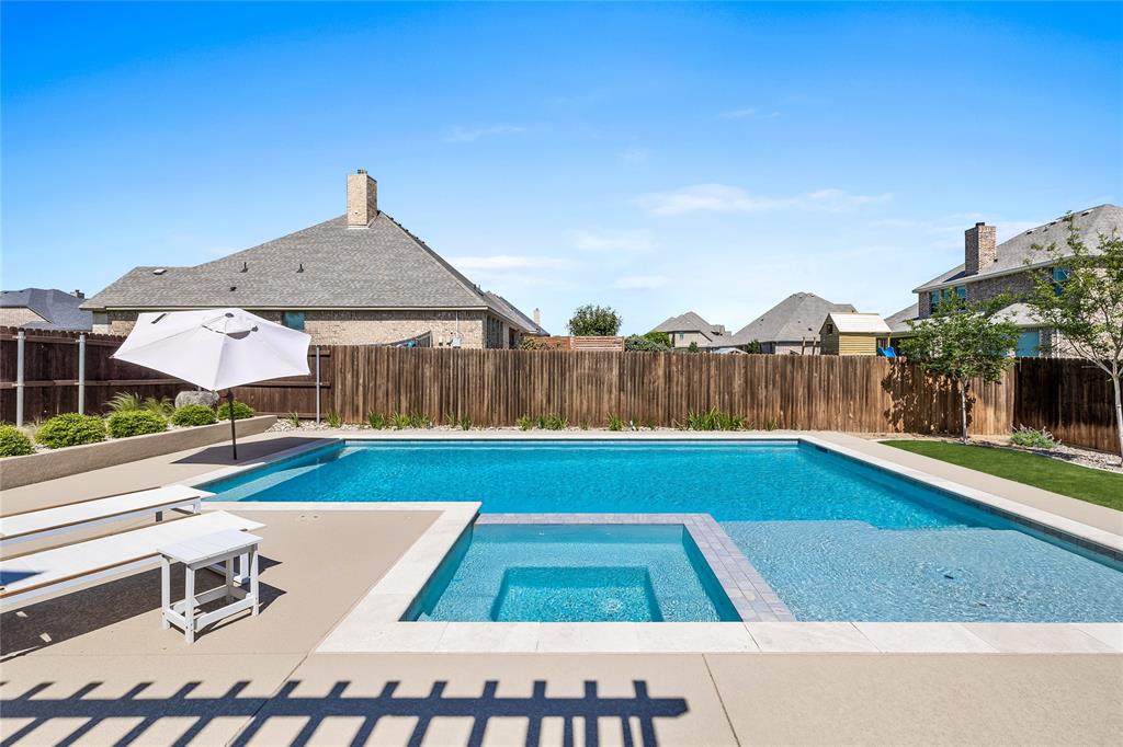 a view of a backyard with a table and chair under an umbrella