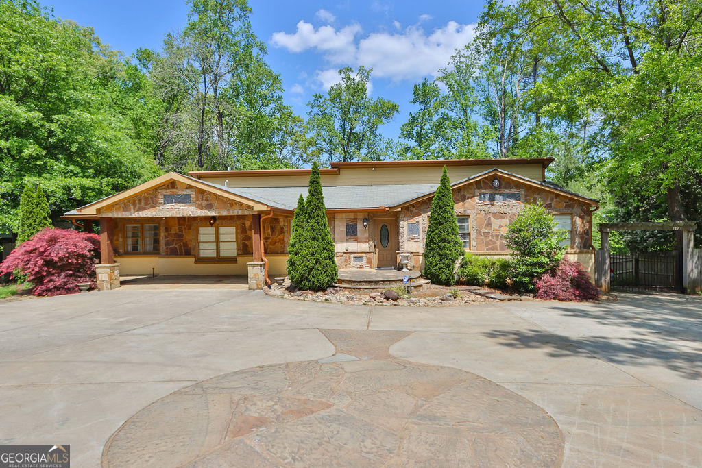 a front view of a house with a garden and trees