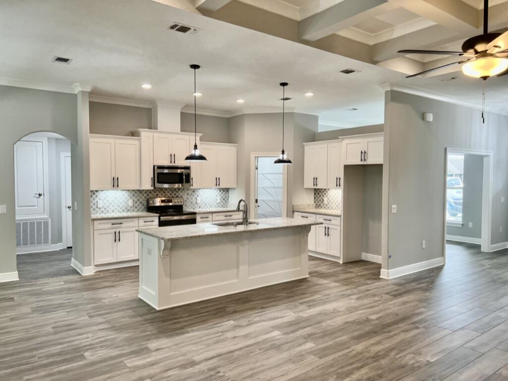 a kitchen with stainless steel appliances a refrigerator stove microwave and cabinets