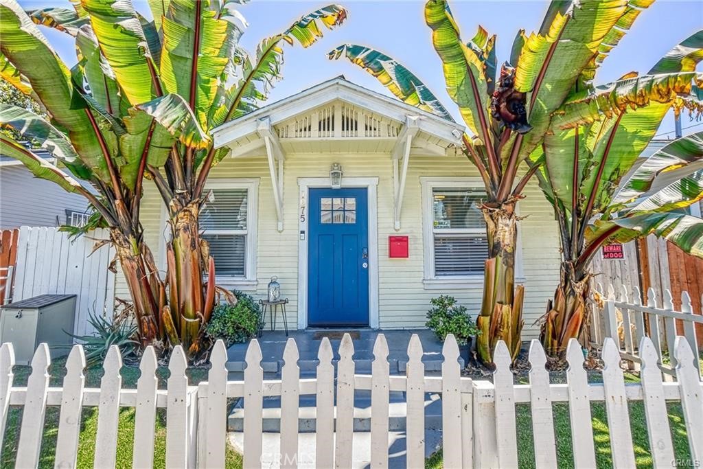 a front view of a house with a tree