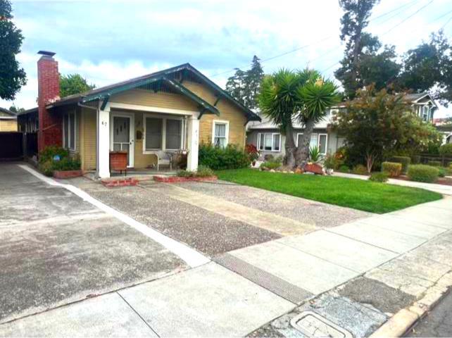 a front view of a house with a yard and potted plants