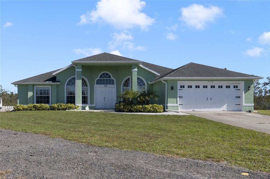 a front view of a house with a garden and yard