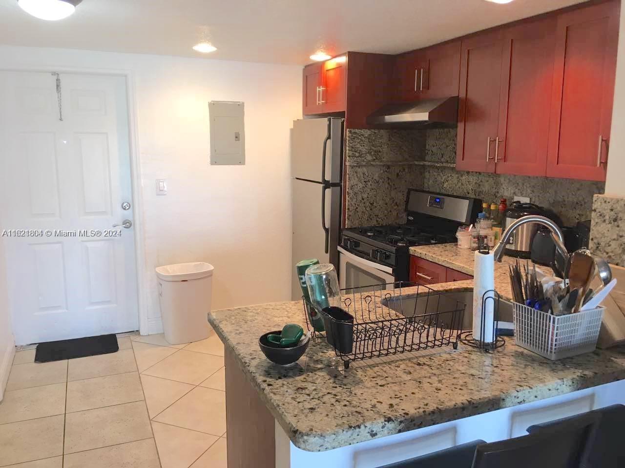 a kitchen with a sink a refrigerator and cabinets