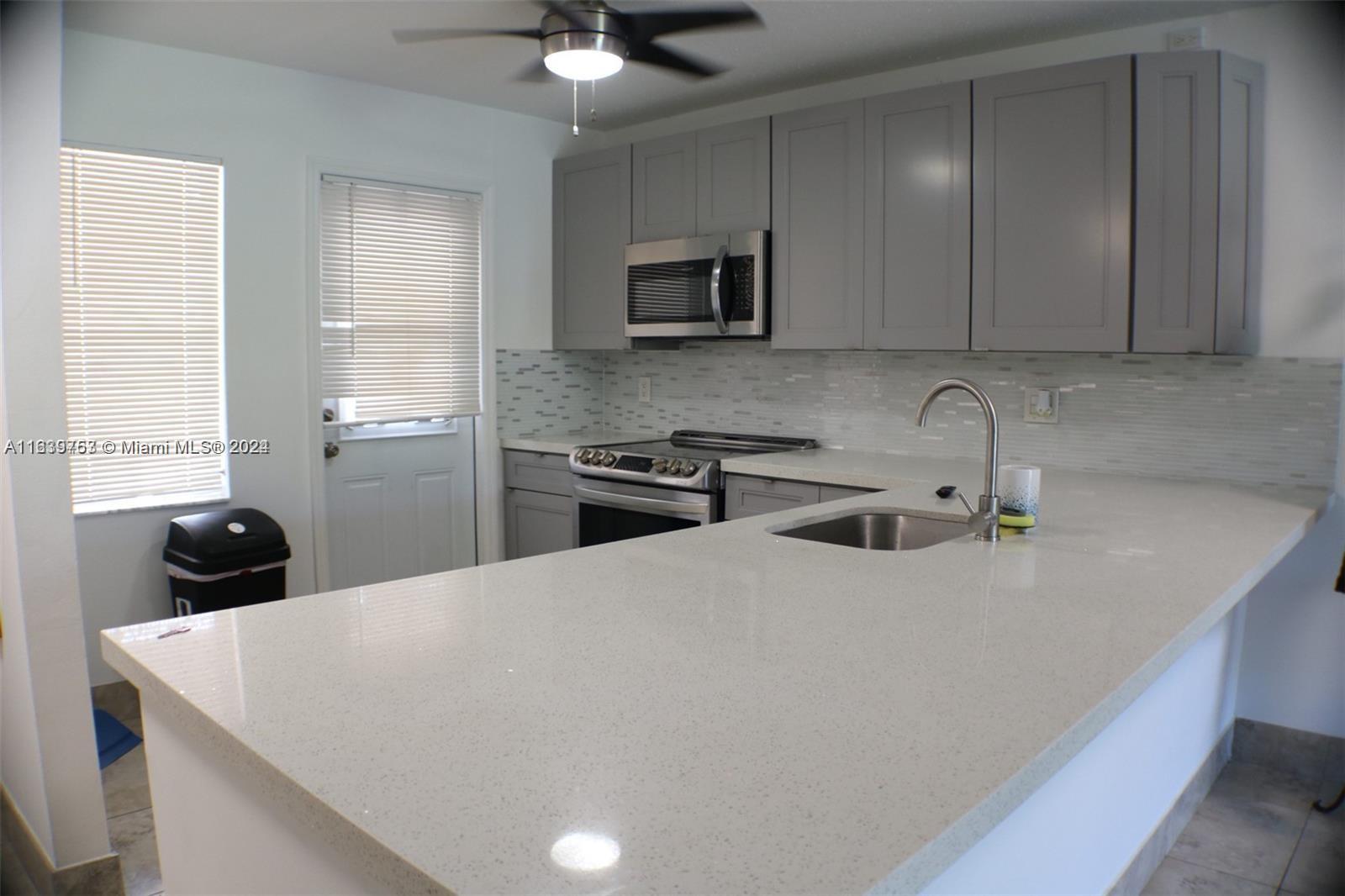 a kitchen with a sink a stove and cabinets