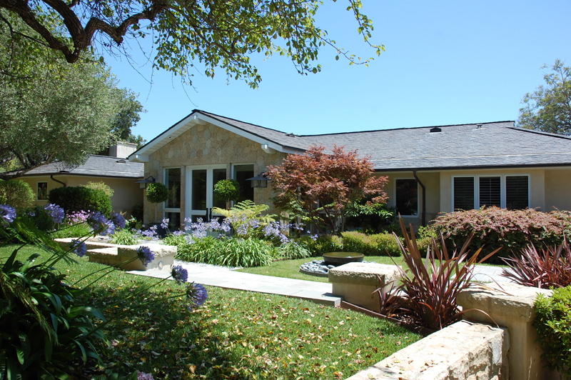 a front view of house with a garden