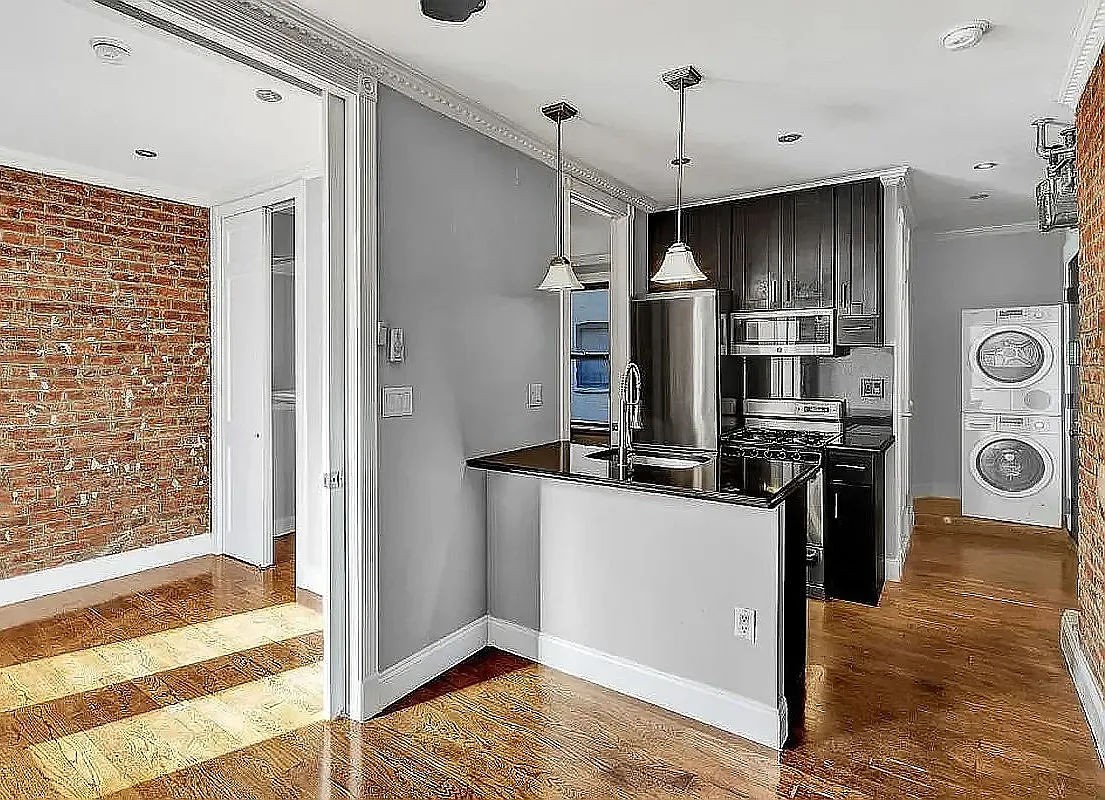 a kitchen with stainless steel appliances kitchen island granite countertop a refrigerator and a stove top oven