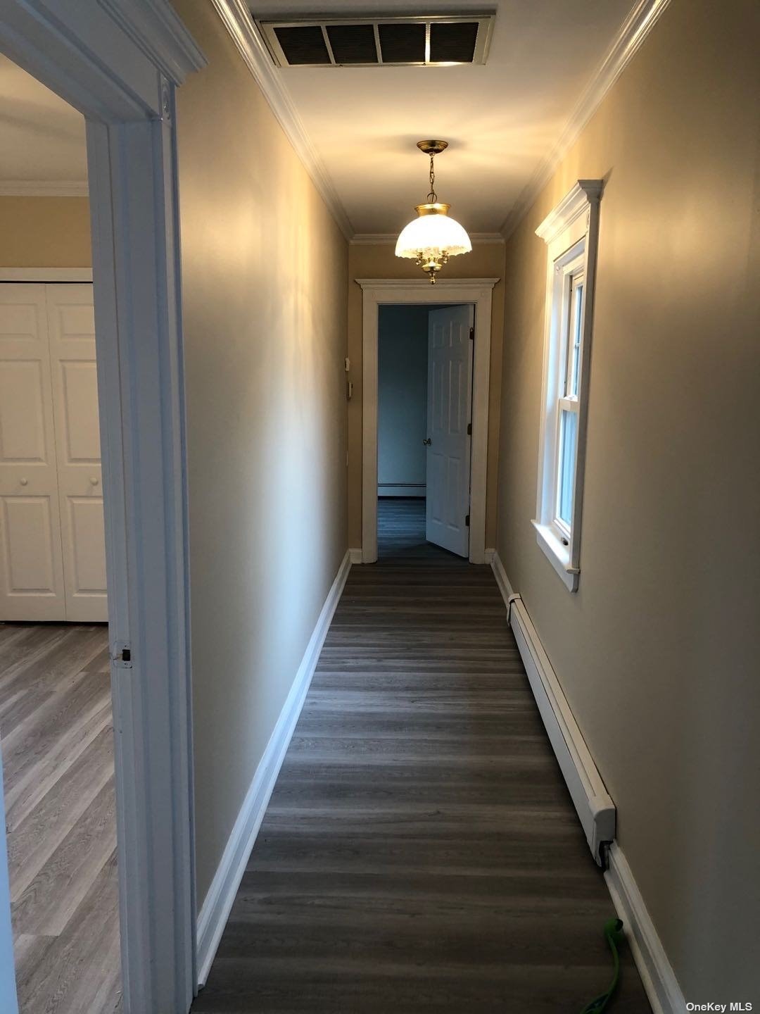 a view of a hallway with wooden floor and staircase