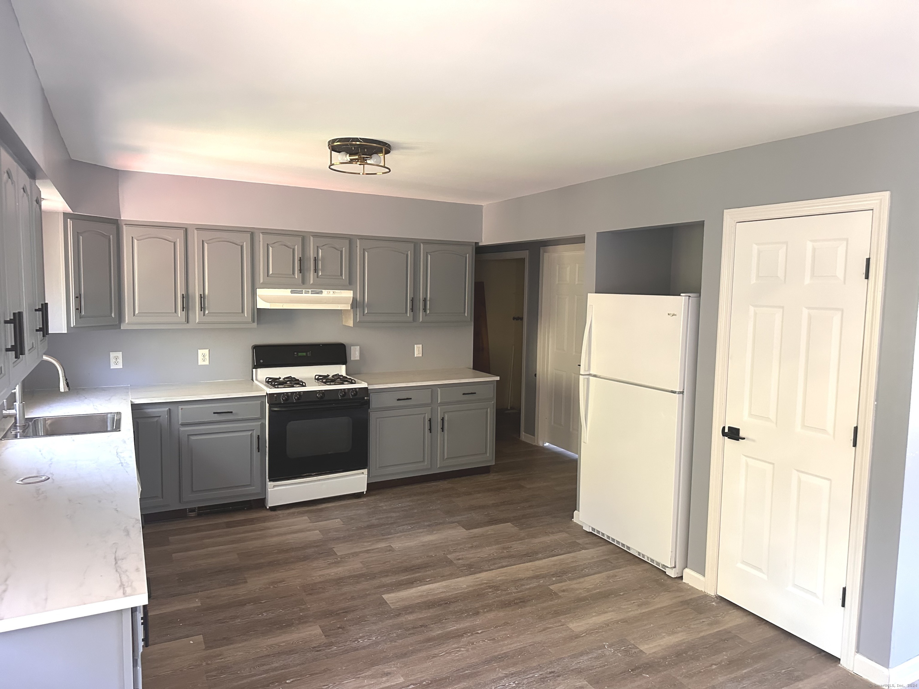 a kitchen with a refrigerator sink and cabinets