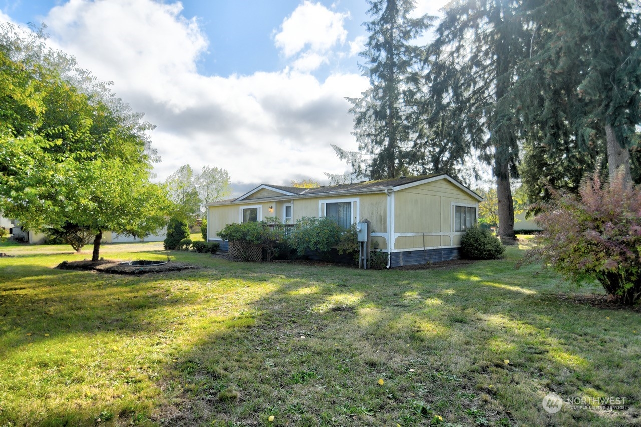 a view of a house with a big yard and a large tree