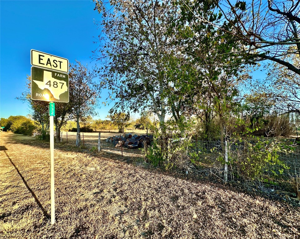 a view of a street with wooden fence