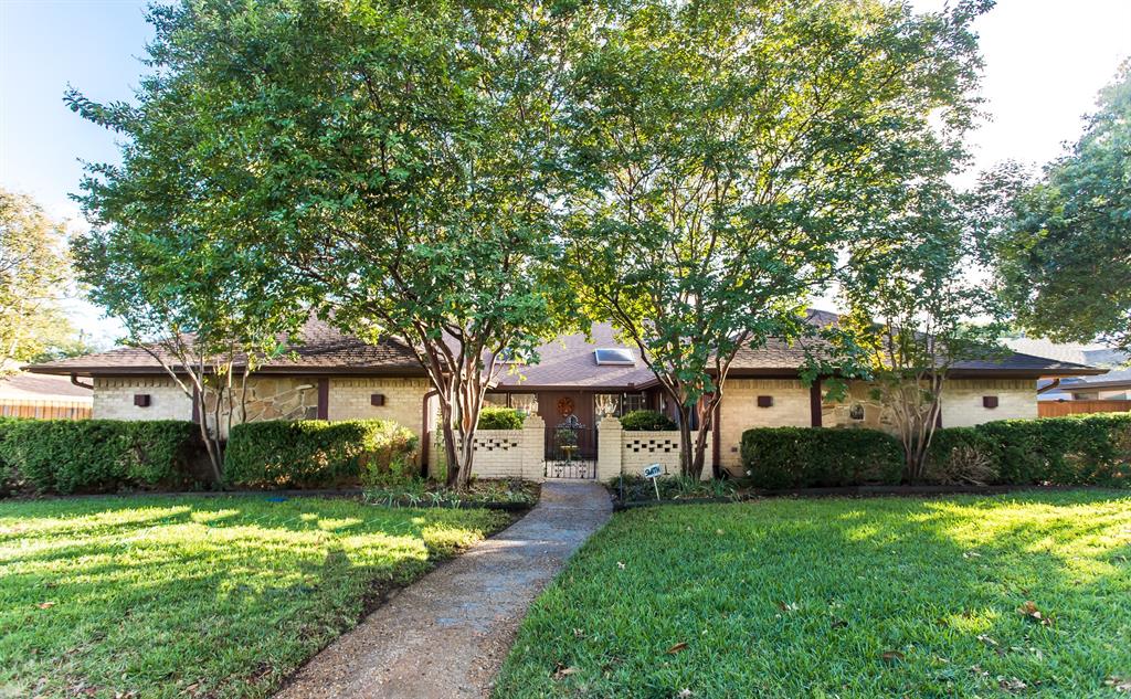 a front view of a house with a yard and trees