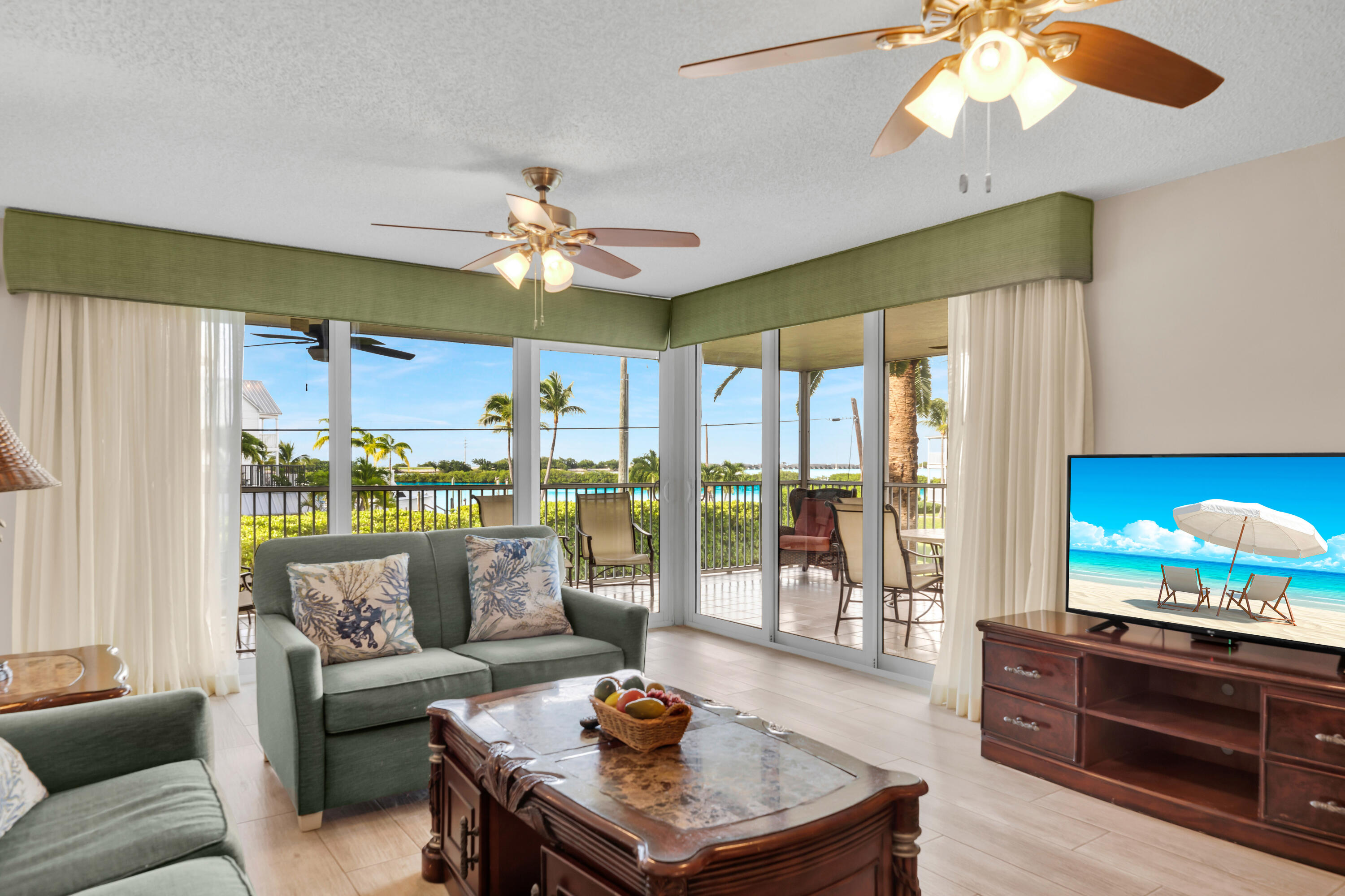 a living room with furniture a flat screen tv and a large window