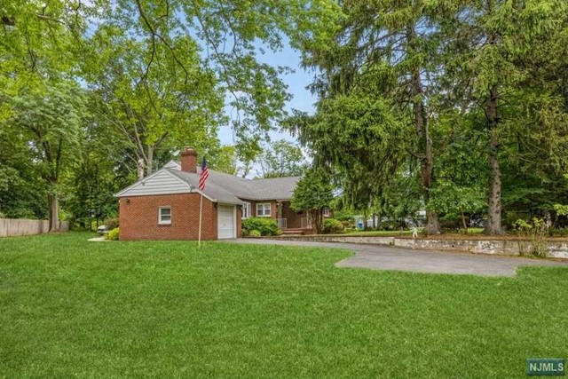 a front view of a house with a yard and trees