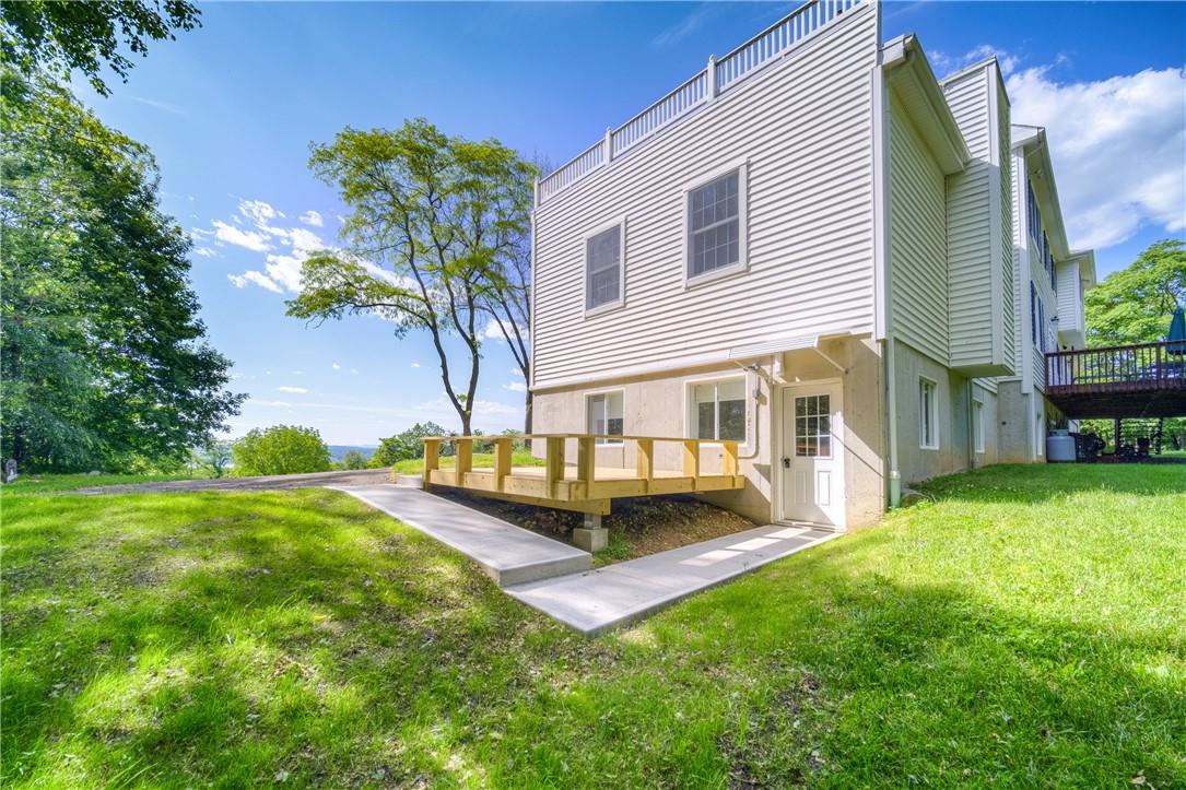 Back of property featuring a deck and a yard