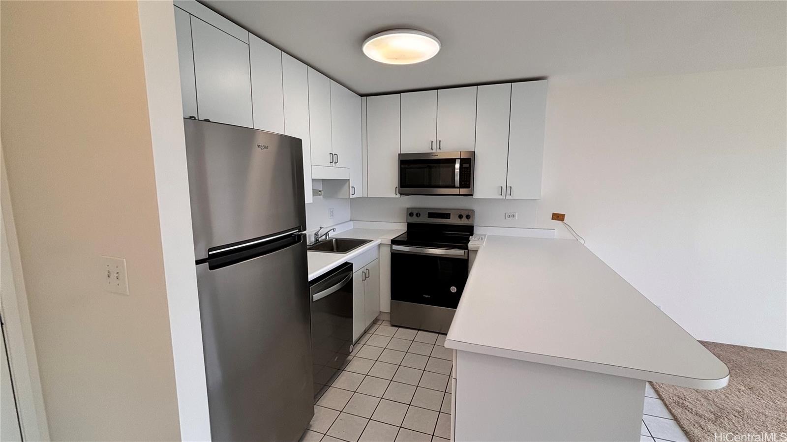 a kitchen with a refrigerator a microwave a sink and cabinets