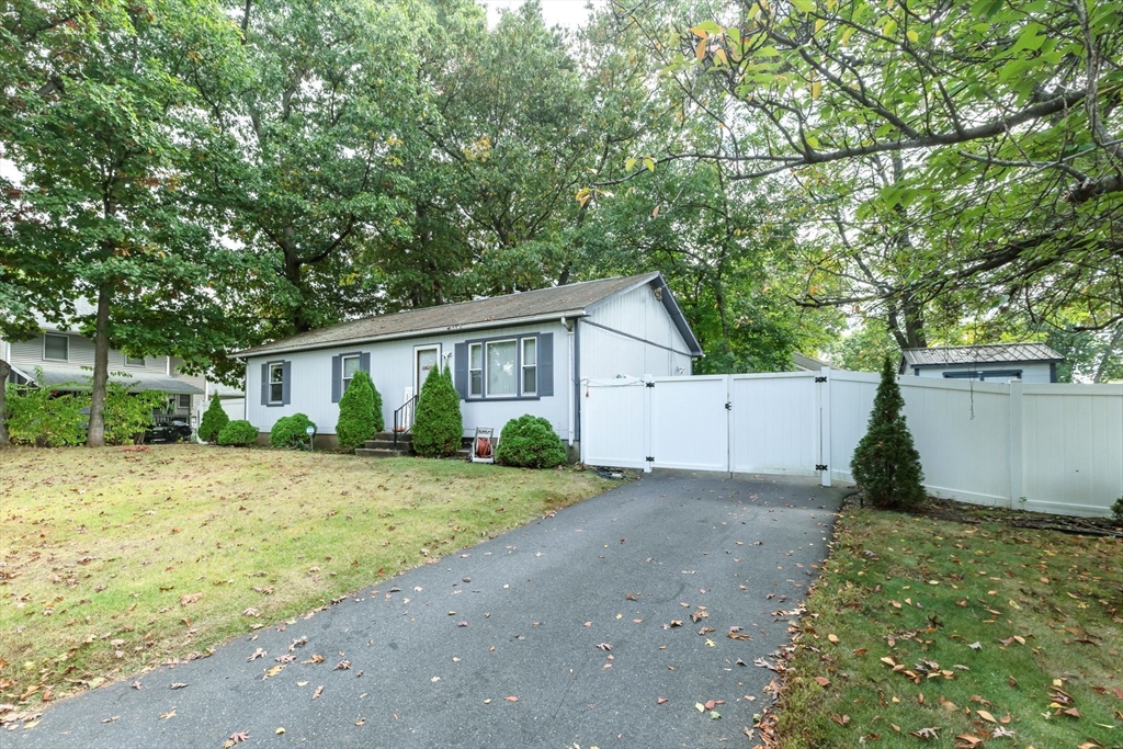 a view of a yard in front of a house with a large tree