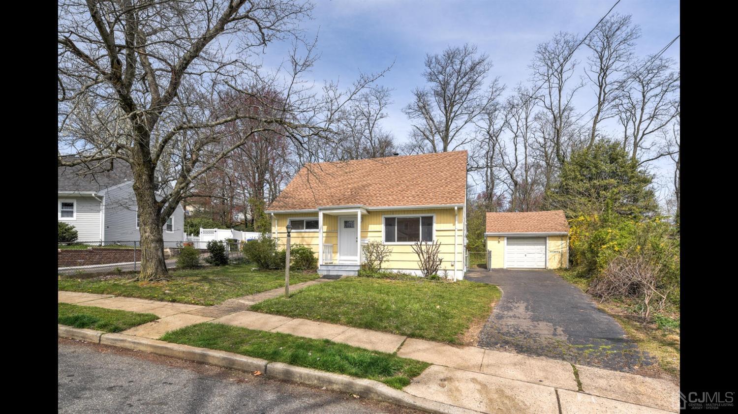 a front view of a house with a yard and trees