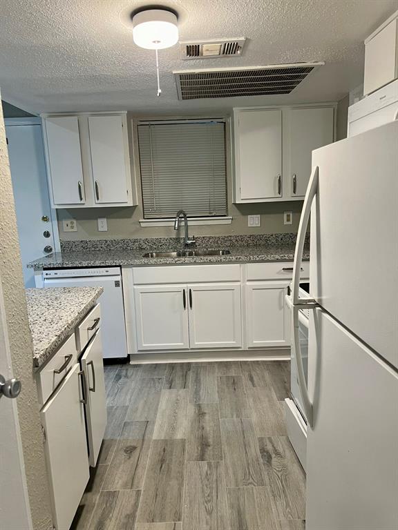 a kitchen with a sink a refrigerator and a stove top oven