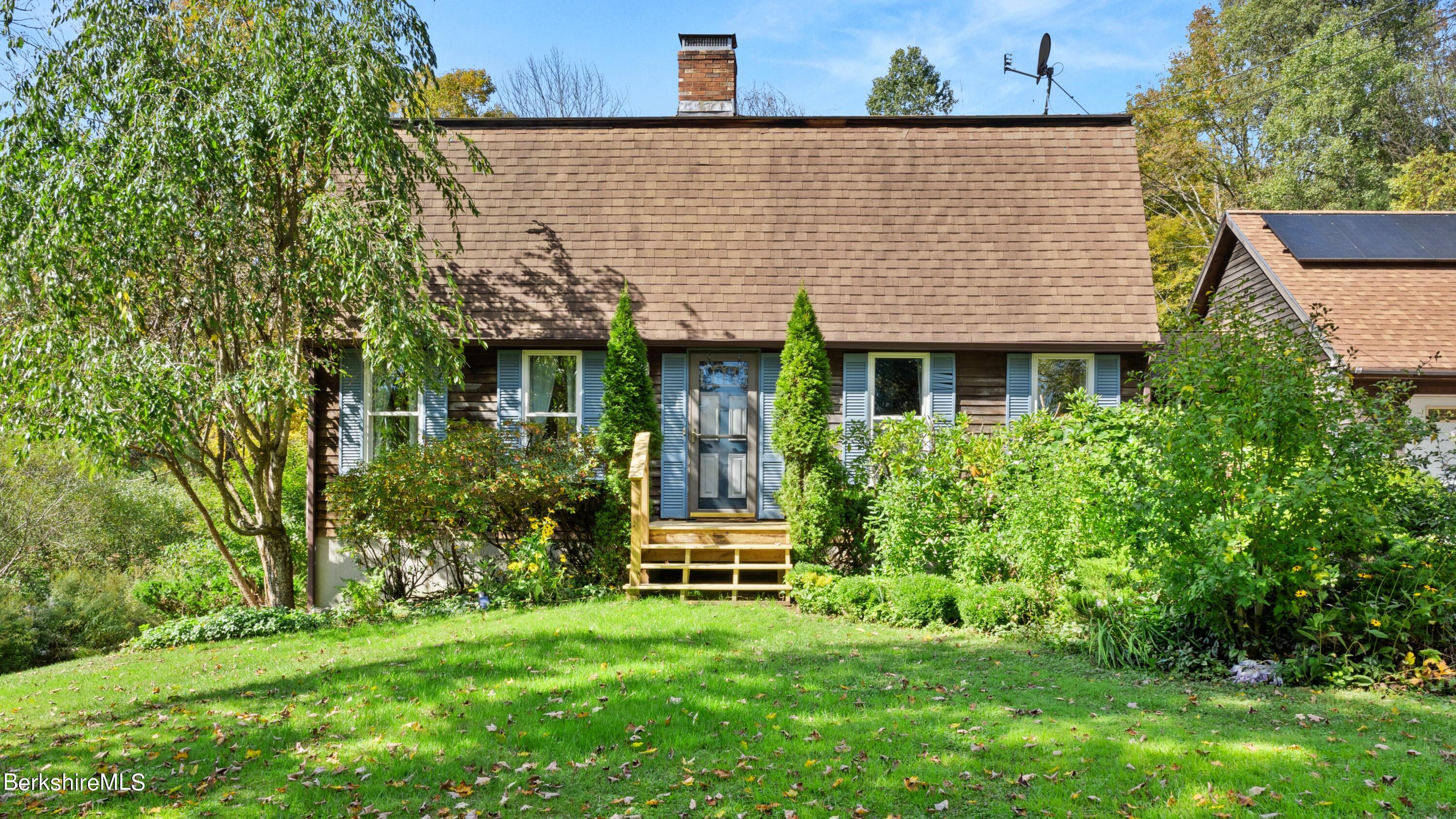 a front view of a house with a garden