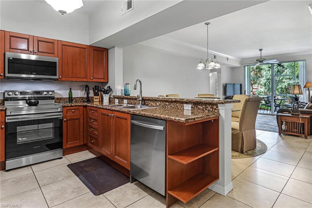 a kitchen with stainless steel appliances granite countertop a stove a sink and a microwave