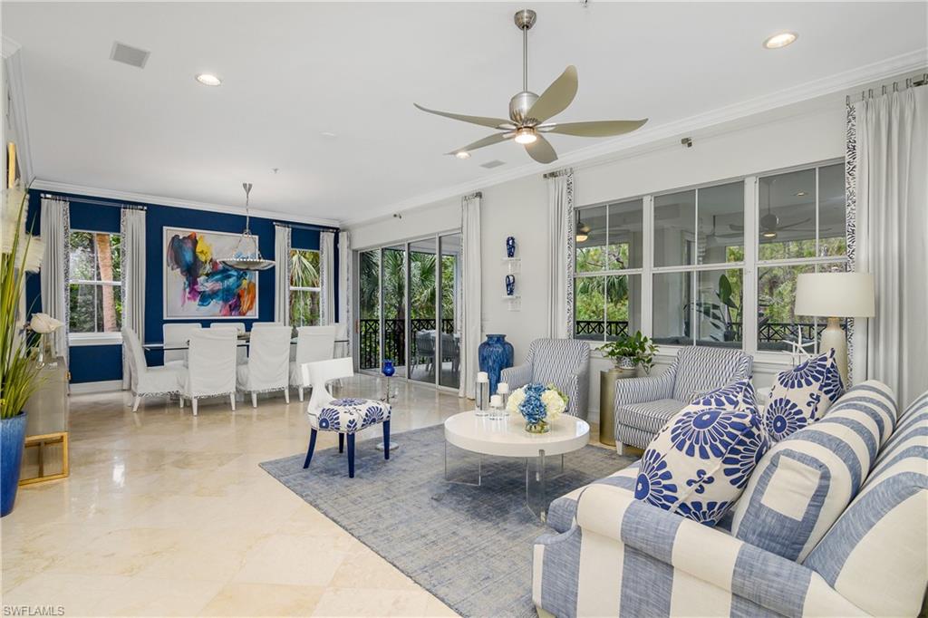 Tiled living room floor featuring a lot of natural light, crown molding, and ceiling fan.