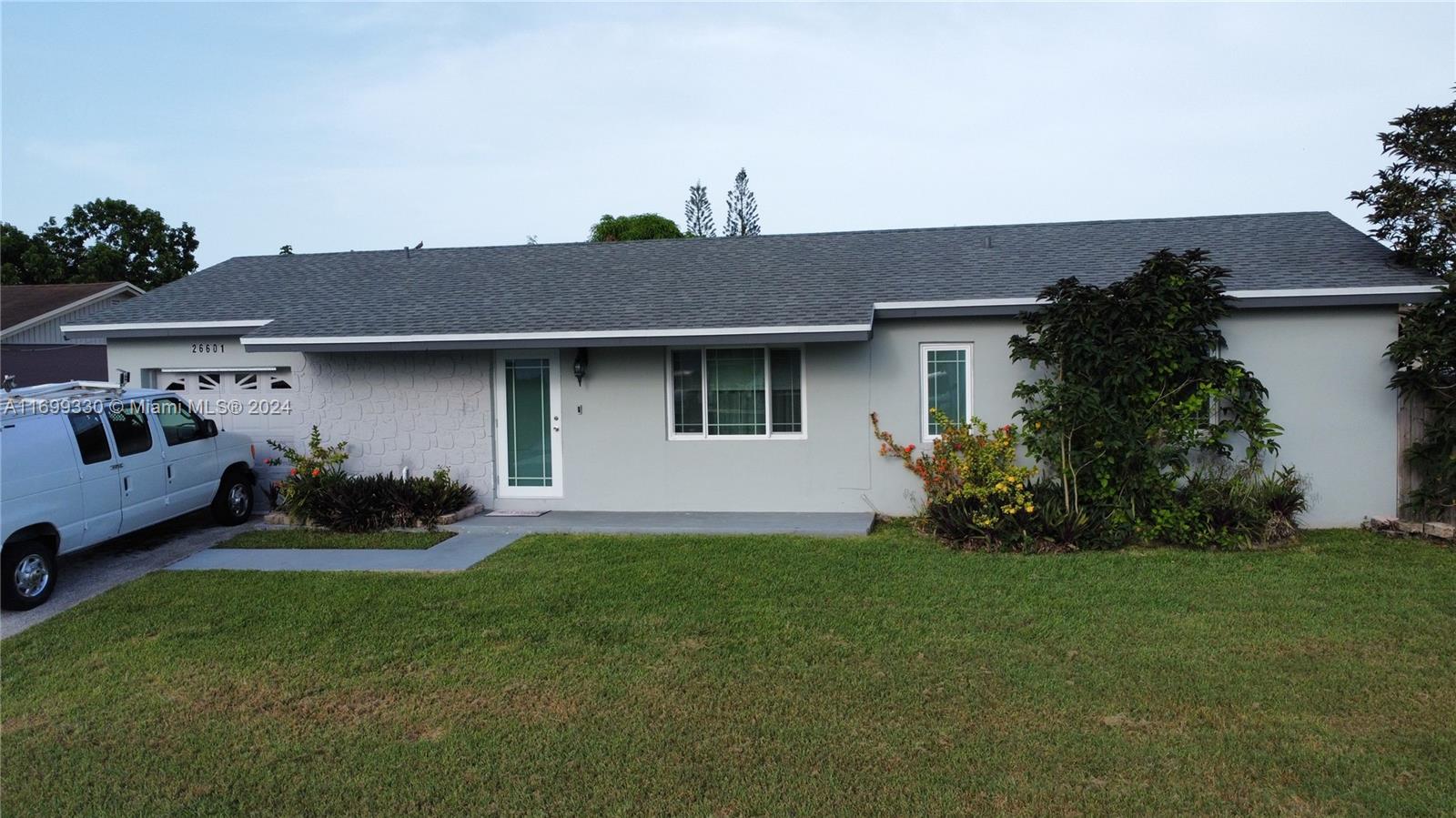 a front view of a house with a garden and yard