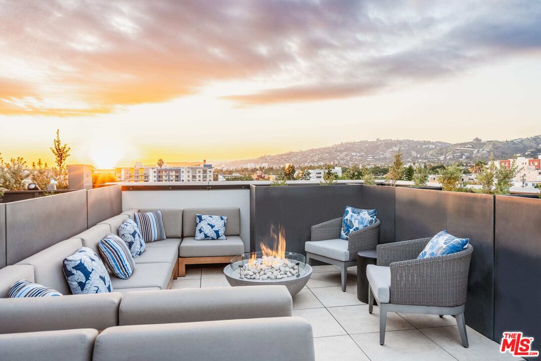 a view of a couch in the roof deck with a barbeque and a couch