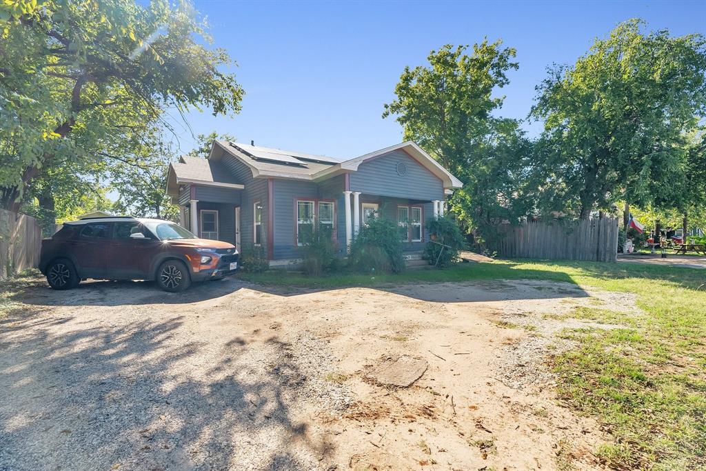 a front view of a house with a yard covered with trees