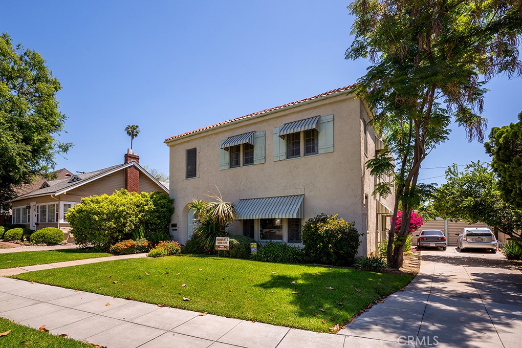 a front view of a house with a yard and potted plants